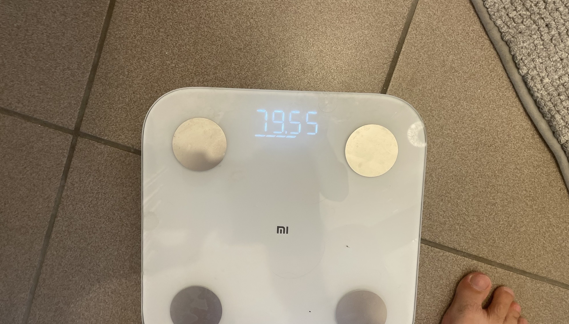 Bathroom scale showing 79.55 kg