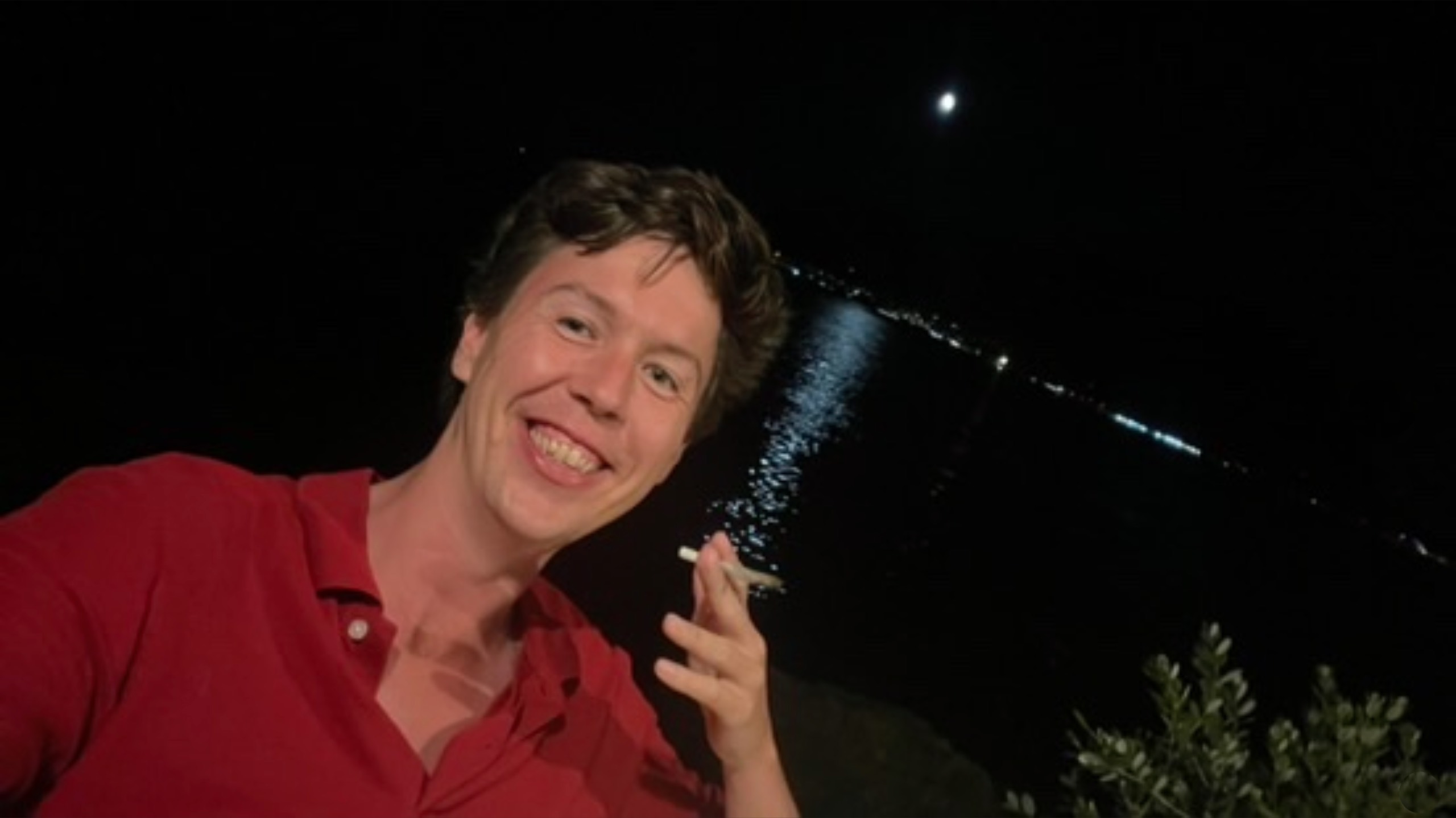Nighttime selfie by the water with the moon reflecting on the sea