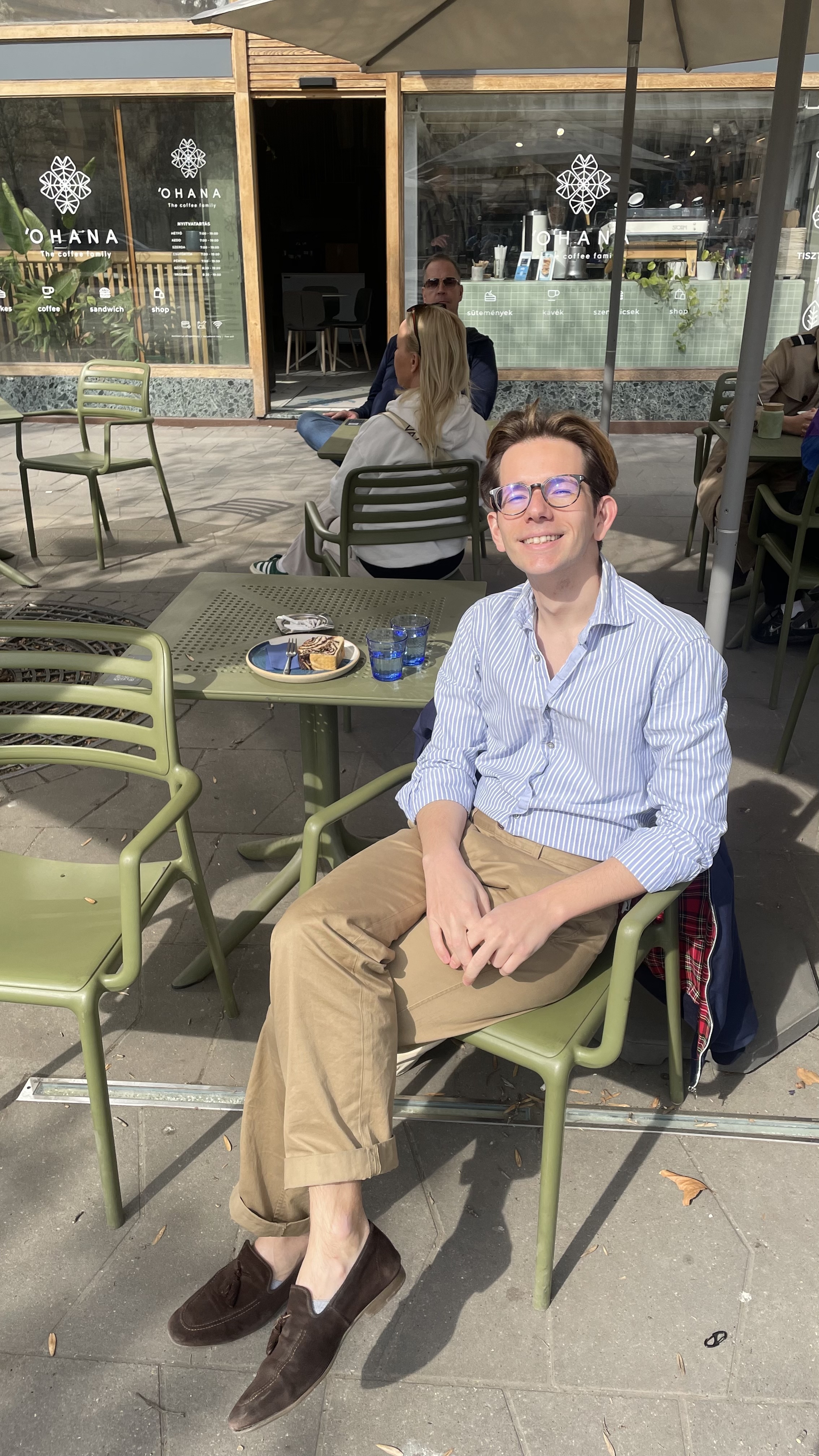 Man sitting alone on a bench outdoors, reading a book